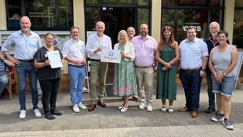 Familienministerin Stolz steht mit mehreren Personen vor dem Familienzentrum.