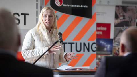 Gesundheitsministerin Stolz zu Besuch bei der DRK-Rettungswache Flörsheim-Wicker Gesundheitsministerin Stolz spricht in ein Mikrofon.