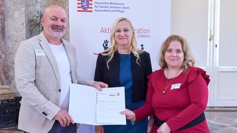 Die Preisträgerin und der Preisträger des Projekts „Merenberg macht mit“ werden ausgezeichnet. Familienministerin Diana Stolz steht mit zwei weiteren Personen vor der Kamera