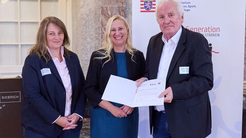 Die Preisträgerin und der Preisträger des Projekts „Generationenpark Hegbachsee“ werden ausgezeichnet. Familienministerin Diana Stolz steht mit zwei weiteren Personen vor der Kamera.