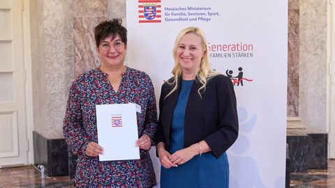 Die Preisträgerin des Projekts „aktivWeg“ wird ausgezeichnet. Familienministerin Diana Stolz steht mit einer weiteren Person vor der Kamera.