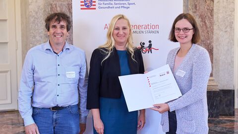 Die Preisträgerin und der Preisträger des Projekts „Der Werratalverein – ein Verein für alle Generationen“ werden ausgezeichnet. Familienministerin Diana Stolz steht mit zwei weiteren Personen vor der Kamera.