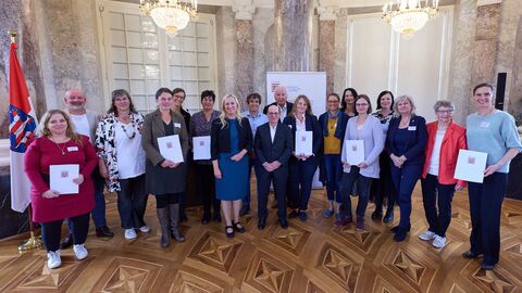 Gruppenfoto der Preisträgerinnen und Preisträger sowie der Familienministerin Diana Stolz. Eine Gruppe von Menschen steht vor der Kamera.