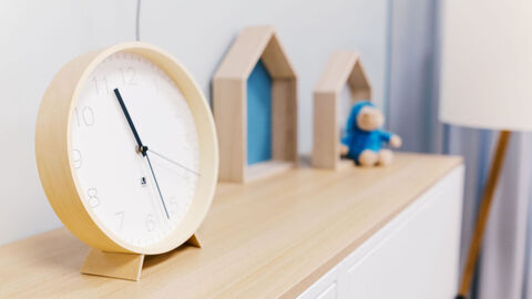 Kommode mit einer Holzuhr und Kinderspielzeug