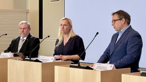 Gesundheitsministerin Diana Stolz (mitte) bei der gemeinsamen Pressekonferenz mit dem Präsident der Hessischen Krankenhausgesellschaft Prof. Dr. Christian Höftberger (rechts) sowie dem Vorstandvorsitzenden der Kassenärztlichen Vereinigung Hessen Frank Daystych (links). Zwei Männer und eine Frau stehen jeweils an einem Rednerpult.
