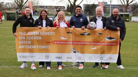 Diana Stolz (rote Jacke) präsentiert gemeinsam mit den Partnerinnen und Partnern von MAKKABI Deutschland und der Sportjugend Hessen die Schnürsenkel-Kampagne gegen Antisemitismus