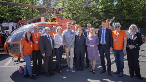 Gesundheitsministerin Diana Stolz steht mit weiteren Personen vor dem Hubschrauber
