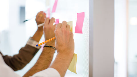 Menschen schreiben auf Post-It's