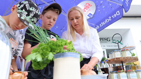 Frau mit zwei Kindern am Essen zubereiten.