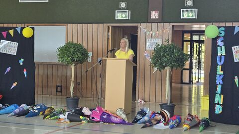 Frau steht an Rednerpult. 