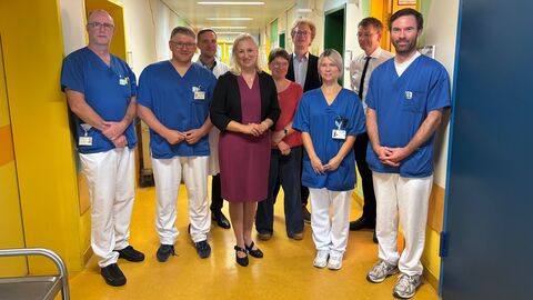 Mehrere Personen stehen zusammen in Klinik.