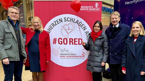 Fünf Personen stehen vor einem roten Plakataufsteller mit der Aufschrift "GoRed"